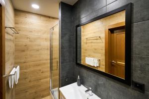 a bathroom with a sink and a mirror at Prestige Apartamenty VINCI Centrum in Kielce