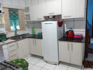 a kitchen with white cabinets and a white refrigerator at Casa na Praia de Ponta de Pedras in Alter do Chao
