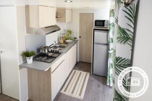 a small kitchen with a stove and a refrigerator at Camping Le Roussillon - Maeva in Saint-Cyprien