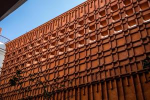 a brown brick wall with squares on it at Hotel Ayook in Oaxaca City