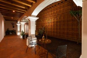 a room with a table and chairs and a brick wall at Hotel Ayook in Oaxaca City