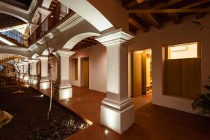a large hallway with white columns in a building at Hotel Ayook in Oaxaca City