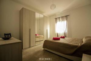 ein Schlafzimmer mit einem Bett und einem großen Spiegel in der Unterkunft Accogliente Bussana 2 in Sanremo