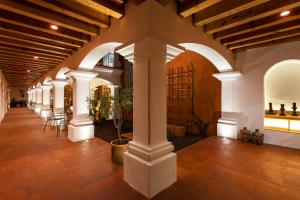 a hallway with white columns and chairs in a building at Hotel Ayook in Oaxaca City