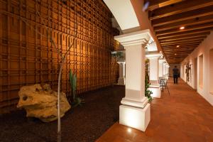 a lobby with a brick wall and a column and a plant at Hotel Ayook in Oaxaca City