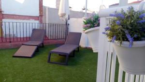 a balcony with two chairs and a potted plant at San Francisco 10 - 6 Apartamentos Boutique en el Centro - Playa Postiguet in Alicante