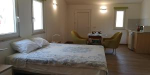 a bedroom with a bed and a table with chairs at Herdade Rodrigo Afonso in São Teotónio