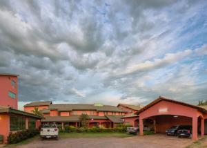 un edificio con coches estacionados en un estacionamiento en Hotel Rancho Verde, en Barreiras