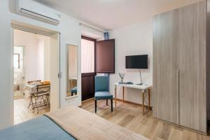 een slaapkamer met een bed en een bureau met een computer bij Centre Apartment Grotte Bianche 2 in Catania