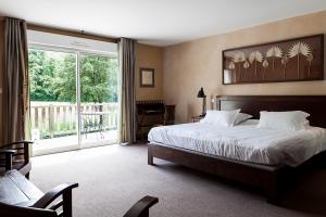 - une chambre avec un lit et une grande fenêtre dans l'établissement Hôtel La Gentilhommière, à Nuits-Saint-Georges