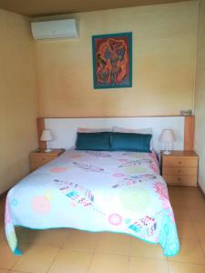 een bed in een slaapkamer met 2 nachtkastjes en 2 lampen bij Posada Chloe Santiago in Santiago de la Ribera