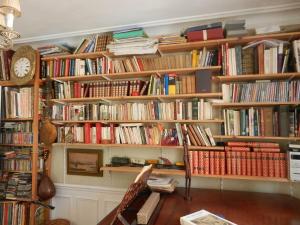 a room with wooden shelves filled with books at Very large private room with own bathroom, in Montmartre apartment in Paris