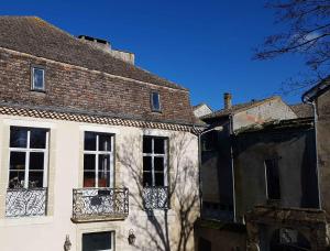 - un bâtiment blanc avec une fenêtre et un balcon dans l'établissement Les remparts de la Bastide, à Castillonnès