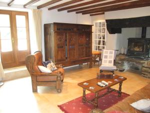 een woonkamer met een bank en een open haard bij Kerlogan in Saint-Thois