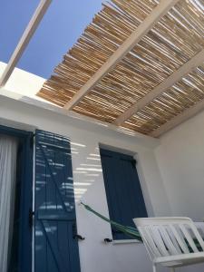 een kamer met een blauwe deur, een witte stoel en een raam bij 7 Olives Apartments in Almirida