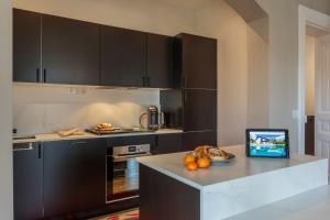 a kitchen with black cabinets and a tablet on a counter at IMPERIAL Apartment in the center of Biarritz close to the beach in Biarritz