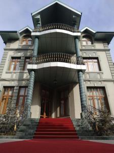 un bâtiment avec un escalier rouge devant lui dans l'établissement Queens Hotel, à Tachkent