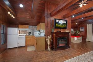 a kitchen with a fireplace and a refrigerator and a stove at Burnin' Love in Gatlinburg