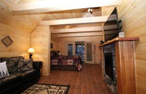 a living room with a fireplace in a log cabin at Sweet Memories in Gatlinburg