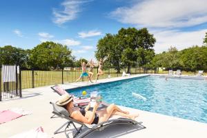 a group of women laying in lawn chairs by a pool at Domaine de l'Oiselière in Chauché