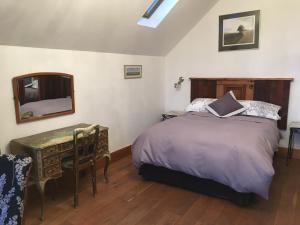 a bedroom with a bed and a desk and a mirror at Horizon Barn in Market Rasen