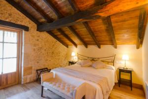 a bedroom with a bed in a room with wooden ceilings at Posada Condado de la Mota in Mogro