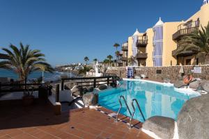 einen Pool mit Blick auf den Strand und die Gebäude in der Unterkunft Luxury Sea Views P67A By CanariasGetaway in Playa del Aguila