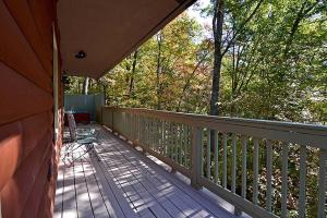 een veranda van een huis met uitzicht op bomen bij Smoky Mountain Dream in Gatlinburg