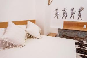 a bedroom with a bed with white sheets and pillows at Hotel Ayook in Oaxaca City