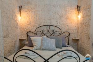 a bedroom with a bed with pillows and a stone wall at Casa Francesca in Ostuni