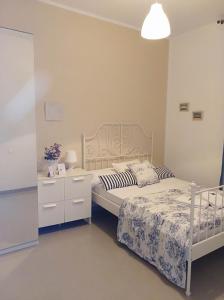 una camera con letto bianco, comodino e sidx sidx. di Pensión Cádiz a Cadice