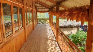 a wooden walkway leading to a building with windows at Hmong Sister House and Trekking in Sa Pa