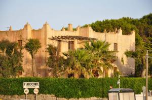 a large building with a palm tree in front of it at Le Mànnare Case Vacanze di Metopa srl in Piano Conte