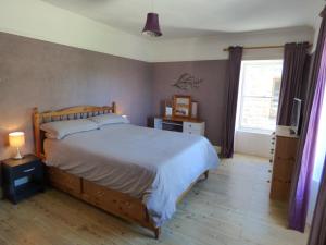 een slaapkamer met een groot bed en een raam bij St Clair House in Orkney +28 foto's