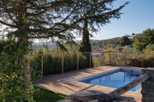una piscina in un cortile con un albero di Casa Rural La Higuera Chica a Málaga