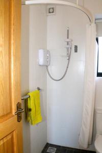 a bathroom with a shower with a yellow towel at Emy Lake Apartment - near Castle Leslie, Glaslough in Monaghan