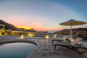uma piscina com duas espreguiçadeiras e um guarda-sol em Naxos Secret Paradise Villa em Galini
