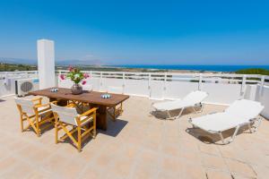 un patio con una mesa de madera y sillas en el techo en Litsa Holiday Home, en Kalathos