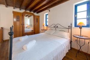 1 dormitorio con 1 cama grande y espejo en Litsa Holiday Home, en Kalathos