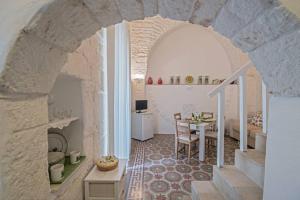 uma sala de estar com uma mesa num quarto com um arco em San Martino, 21 em Carovigno