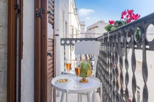 a table with two glasses of wine on a balcony at San Martino, 21 in Carovigno