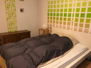 a bed in a room with green and yellow tiles at Ferienwohnung Rhönblick in Fulda