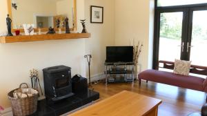 a living room with a stove and a tv at Emy Lake Apartment - near Castle Leslie, Glaslough in Monaghan