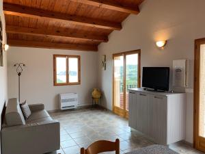 un soggiorno con un divano e una TV di Résidence & SPA Marina d'Arone a Piana