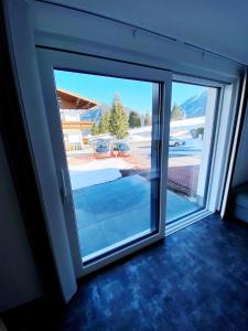 uma porta de vidro deslizante com vista para um quintal em Wellness-Pension Jagahütt'n em Schladming