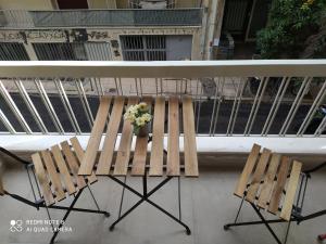 a table with two chairs and a vase of flowers on it at Athens Lycabettus Luxurious Loft in Athens