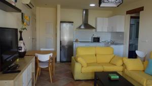アルムニェーカルにあるMarino apartmentのリビングルーム(黄色のソファ付)、キッチンが備わります。
