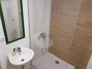 a white bathroom with a shower and a sink at Apartmani Simić Quatro in Valjevo