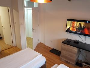a living room with a flat screen tv on a wall at Apartmani Simić Quatro in Valjevo +3 photos