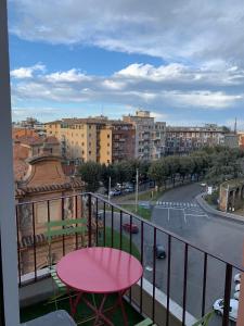 a balcony with a pink table and a view of a city at Stayinbologna 3 in Bologna